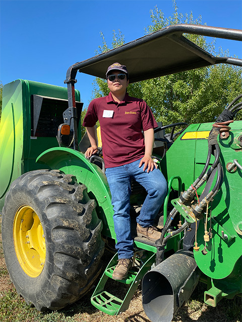A man standing on a large green tractor