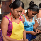 Chocolate making is a social activity for members of the Red de Mujeres who husk roasted cacao beans together.
